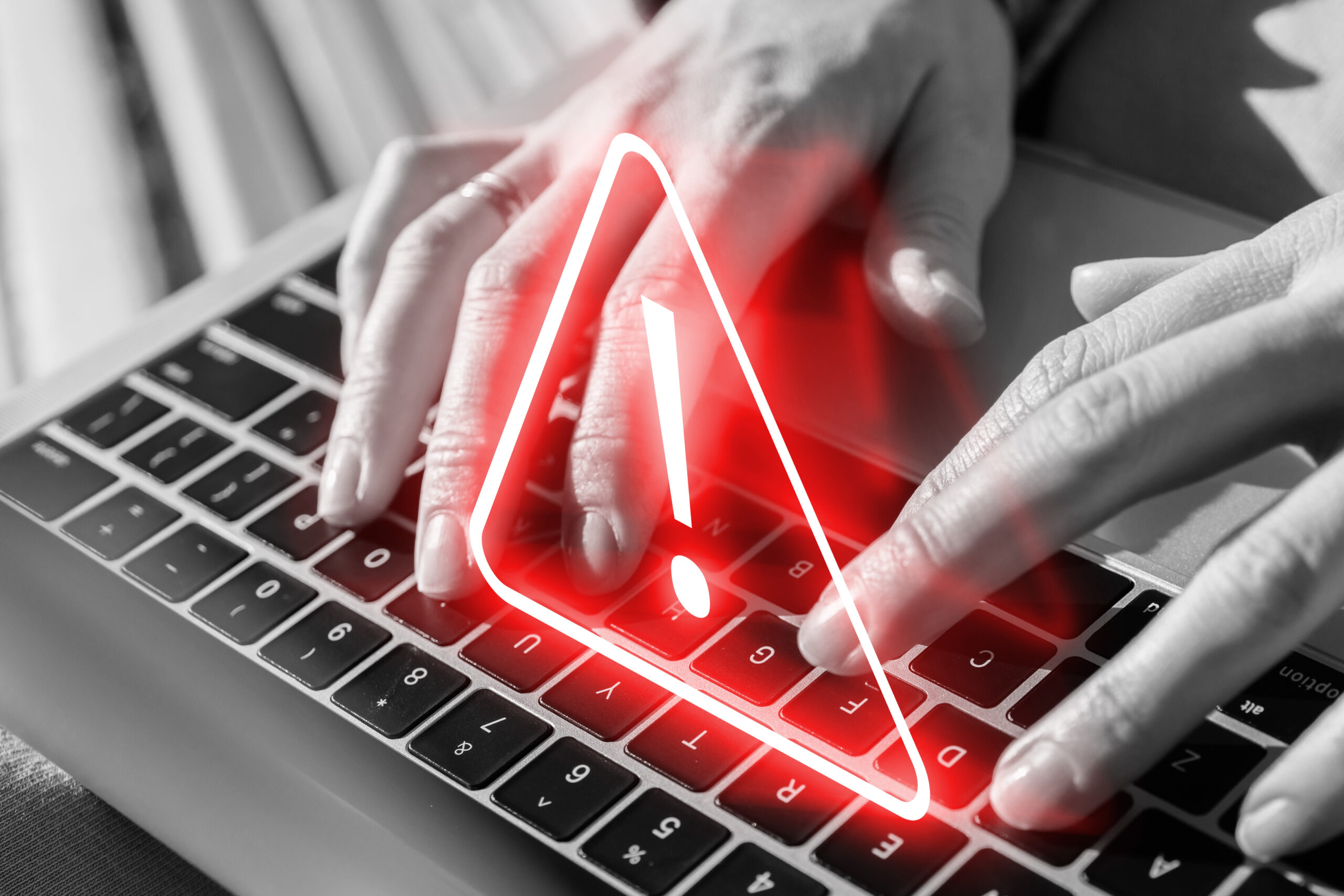 Caution concept. Neon sign over laptop. The person works at the computer